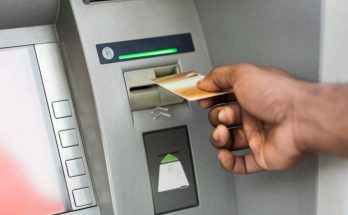 uomo inserisce carte di credito al bancomat